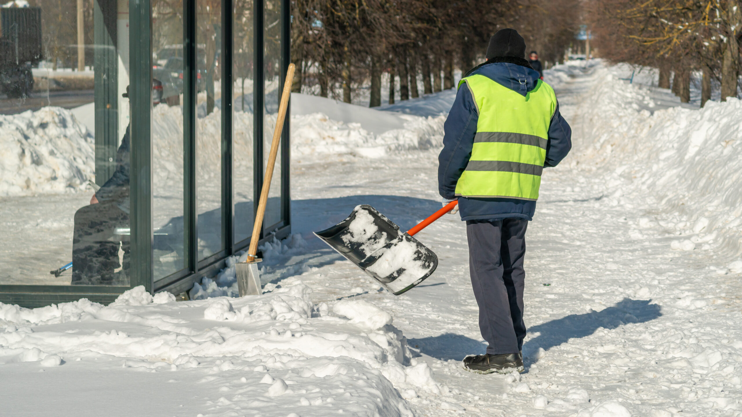 man-shovels-snow-from-building